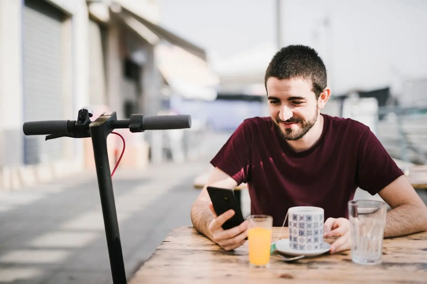 A portrait of a cheerful man next to an e-scooter